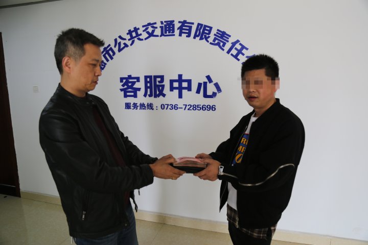 圖為失主熊先生(右)領(lǐng)回失物現(xiàn)場.png